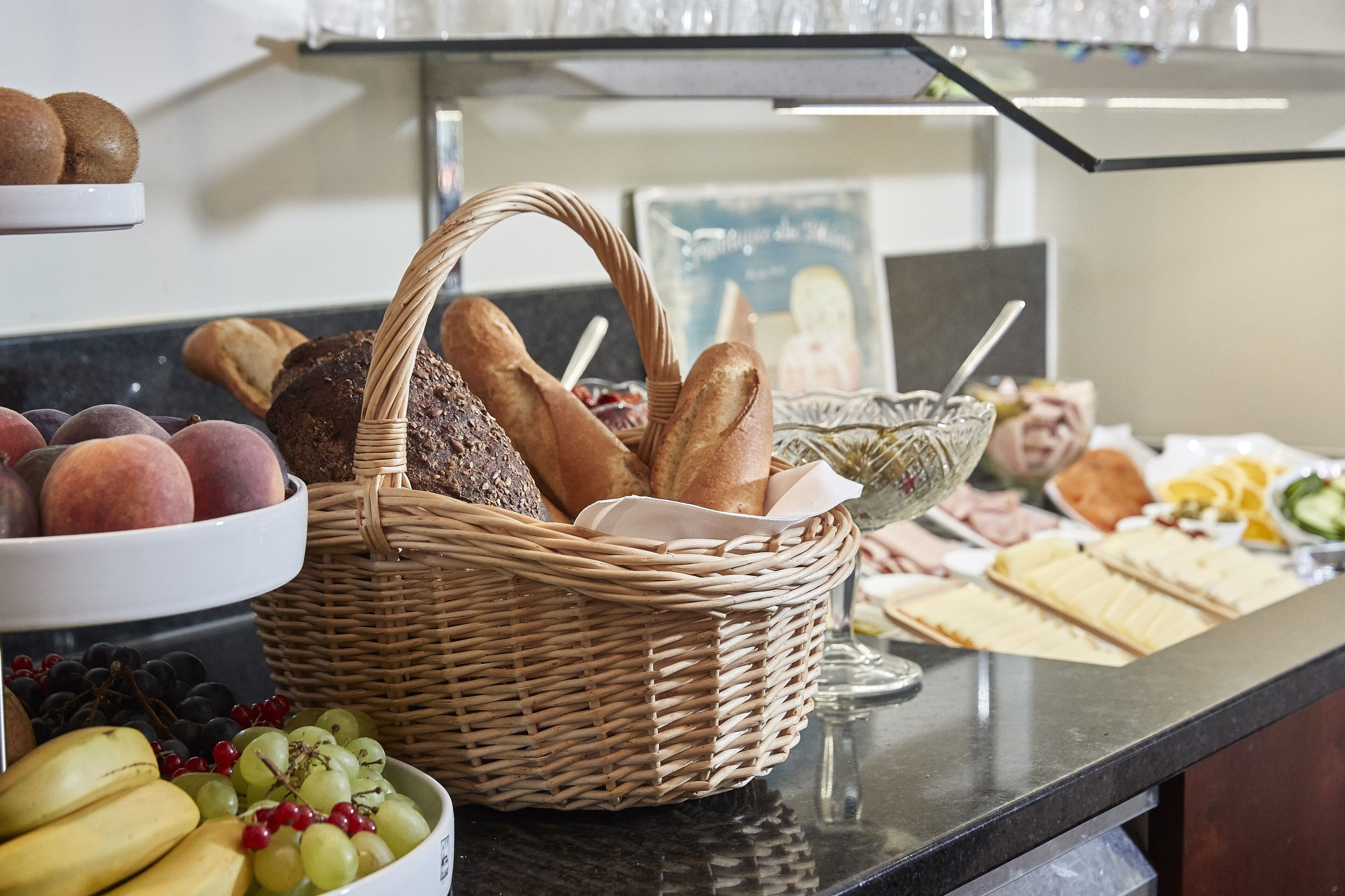 A buffet with various food items including bread, fruits, and sandwiches.