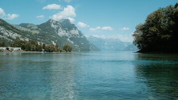 A calm lake with mountains in the background and a clear sky.