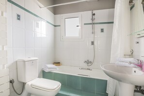 A bathroom with a toilet, bathtub, and sink. - Emily Villas (Kefalonia)