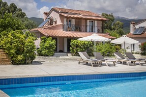 A two-story house with a swimming pool, outdoor seating, and solar panels. - Emily Villas (Kefalonia)
