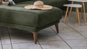 A green sofa with a woven hat, a small round table, and a window with a view. - Emily Villas (Kefalonia)