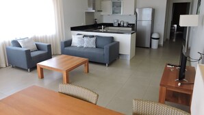 Ein modernes Wohnzimmer mit Sofa, Couchtisch und Essbereich.