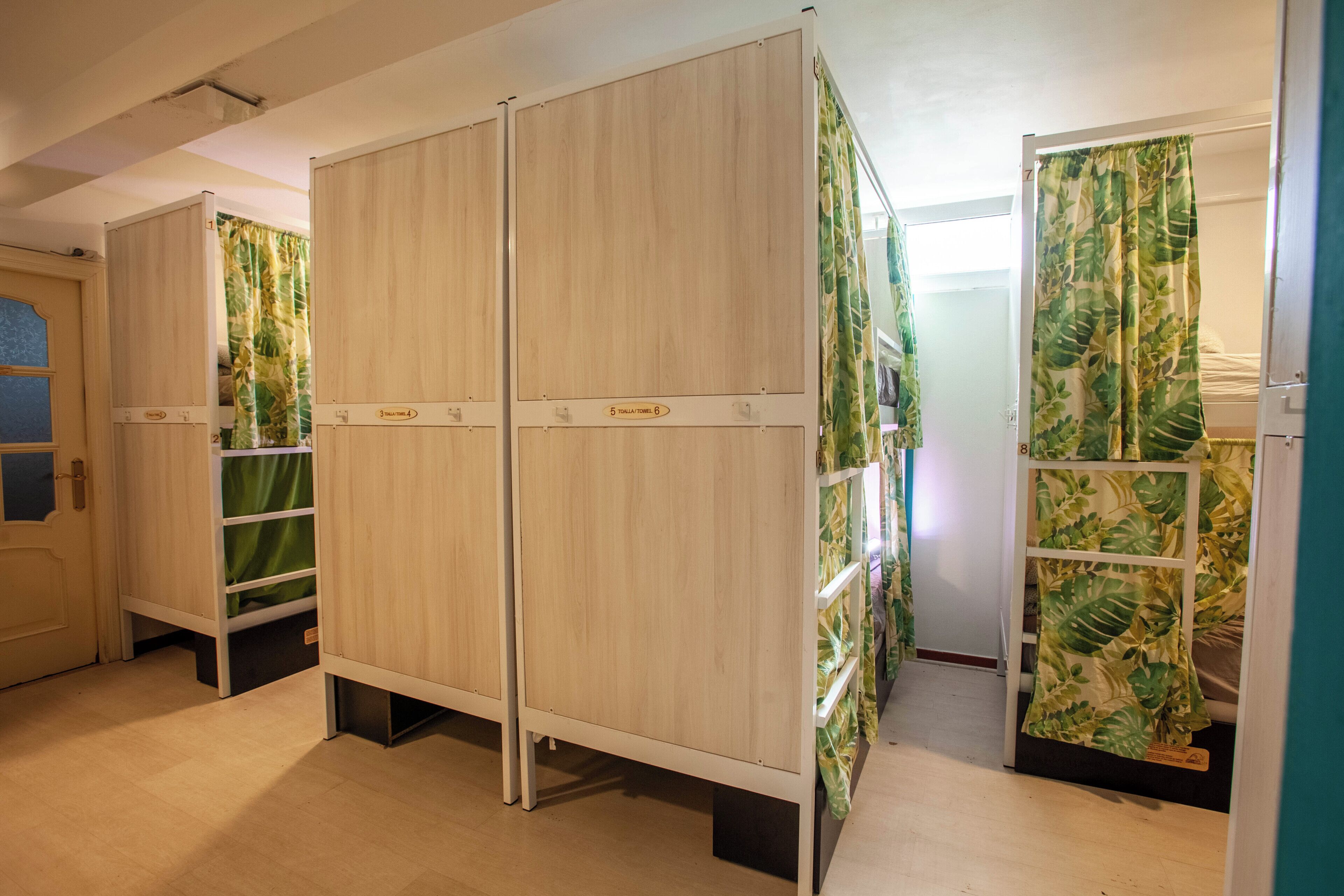 A hotel room with a bed, a wardrobe, and a bathroom.