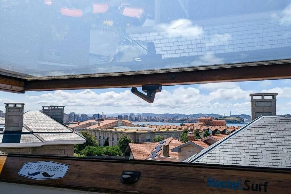 A hotel named 'Hostel Surf' with a view of a cityscape through a skylight.