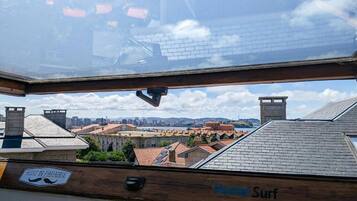 Un hotel llamado 'Hostel Surf' con vista a un paisaje urbano a través de un tragaluz.