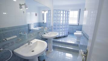 Un baño con dos lavamanos, un espejo y una cabina de ducha.