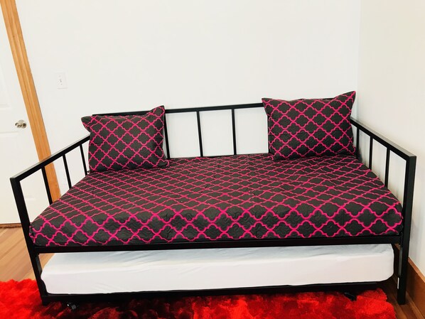 A black metal bed frame with a mattress and two pillows.