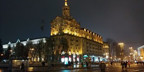 A historic building with ornate architecture, a prominent tower, and a well-lit facade.