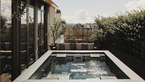 A rooftop pool with a view of the cityscape, surrounded by greenery and modern architecture. - Brach Paris - Evok Collection (Paris)