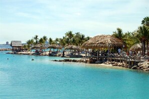En la playa, playa de arena blanca y camastros 