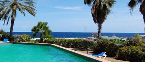 Una piscina al aire libre, sillones reclinables de piscina