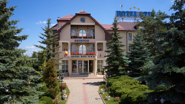 A hotel with a reception area, a balcony with flowers, and a clear sky. - Hotel Stil (Cluj-Napoca)
