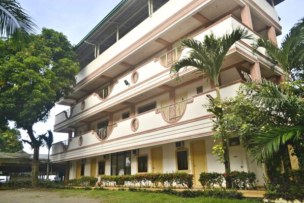 A multi-story building with a symmetrical facade, balconies, and a central entrance.