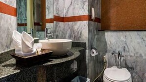 A bathroom with a marble sink, a mirror, and a toilet. - Nipa Resort (Phuket)