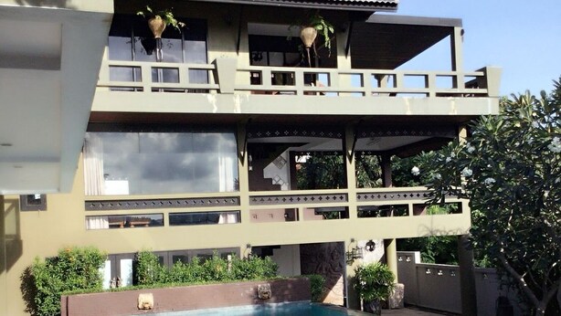 Un bâtiment à deux étages avec une piscine devant.
