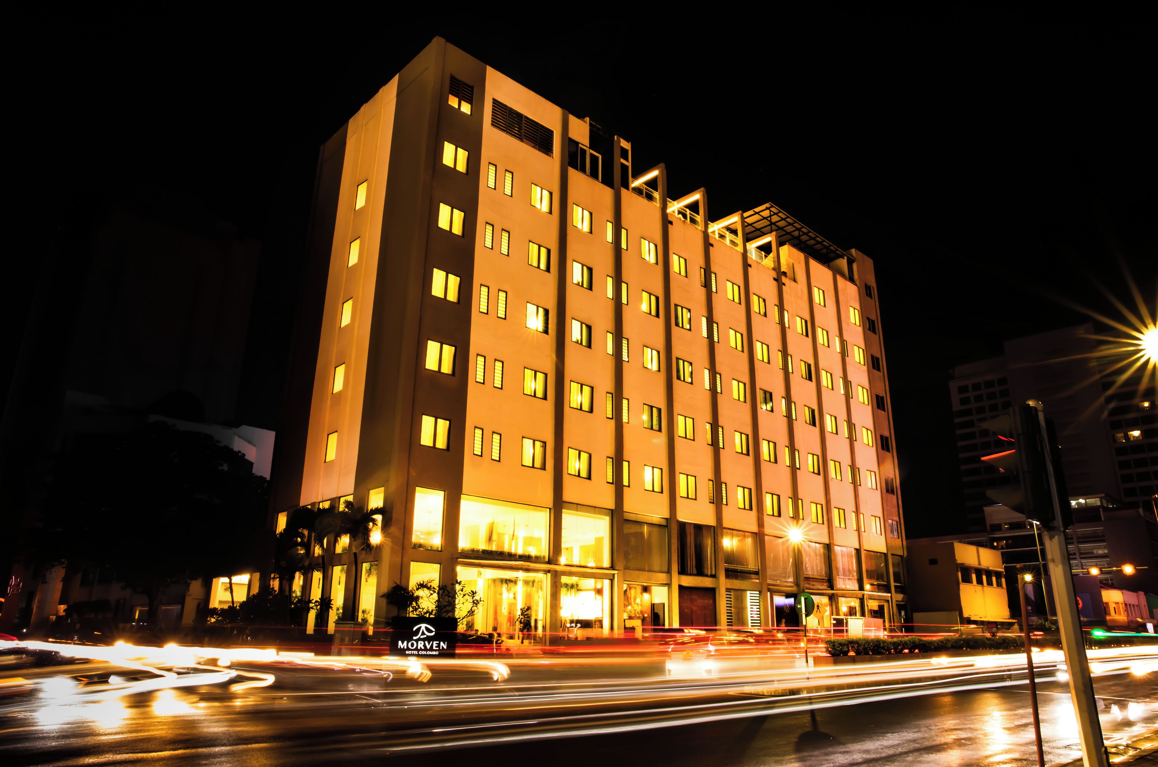A multi-story hotel with illuminated windows and a well-lit entrance.