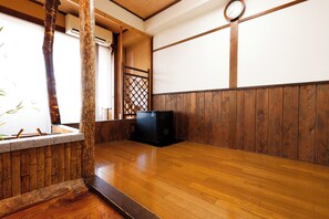 Una habitación japonesa tradicional con suelo de tatami, una separación de madera y un reloj en la pared.