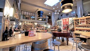 A spacious, well-lit interior with high ceilings, wooden tables, and a variety of seating options. - Charmant T2, hypercentre, calme, terrasse, parking, commerces (Bagnères-De-Luchon)