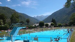 A swimming pool with a diving board, surrounded by mountains and trees. - Charmant T2, hypercentre, calme, terrasse, parking, commerces (Bagnères-De-Luchon)