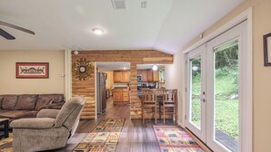 A spacious living area with a sofa, a recliner, and a kitchen in the background.