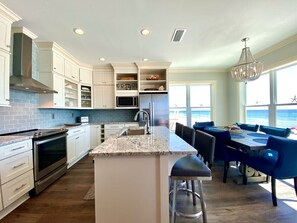 Enjoy ocean views from the spacious kitchen and dining area with a large island and high ceiling.