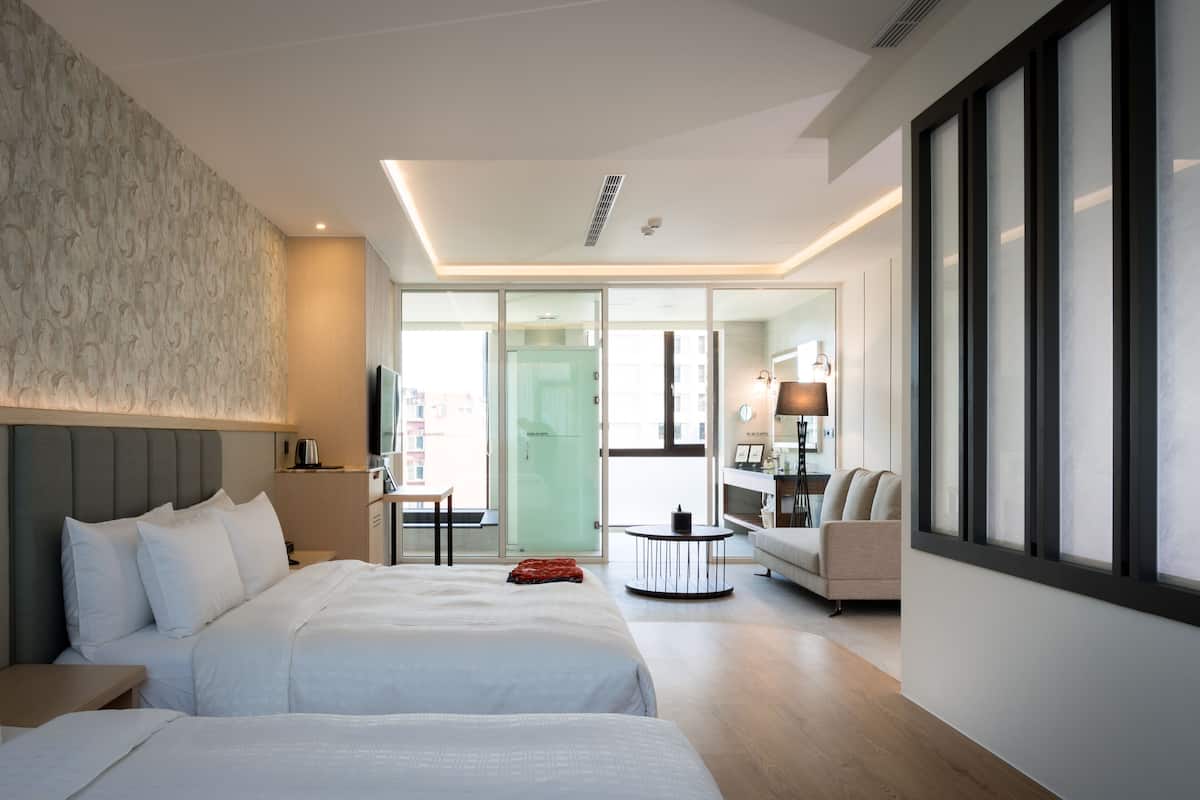 Une chambre d’hôtel avec un grand lit, un bureau, une chaise et un canapé.
