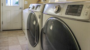 Une buanderie équipée de deux machines à laver à chargement frontal et d’un sèche-linge.