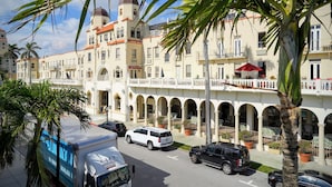 Un hotel con un patio central, varios balcones y una mezcla de estilos arquitectónicos, incluyendo paseos con arcos y estructuras abovedadas.
