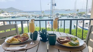 Ein Tisch mit Frühstückstellern, zwei Orangensaftgläsern und einer tropischen Pflanze.