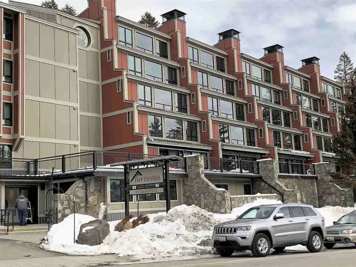 A multi-story building with a stone facade and large windows.