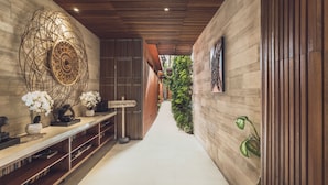 A modern hallway with a wooden ceiling, a decorative wall piece, and a potted plant. - Sana Vie Villa Seminyak by Ini Vie Hospitality (Seminyak)