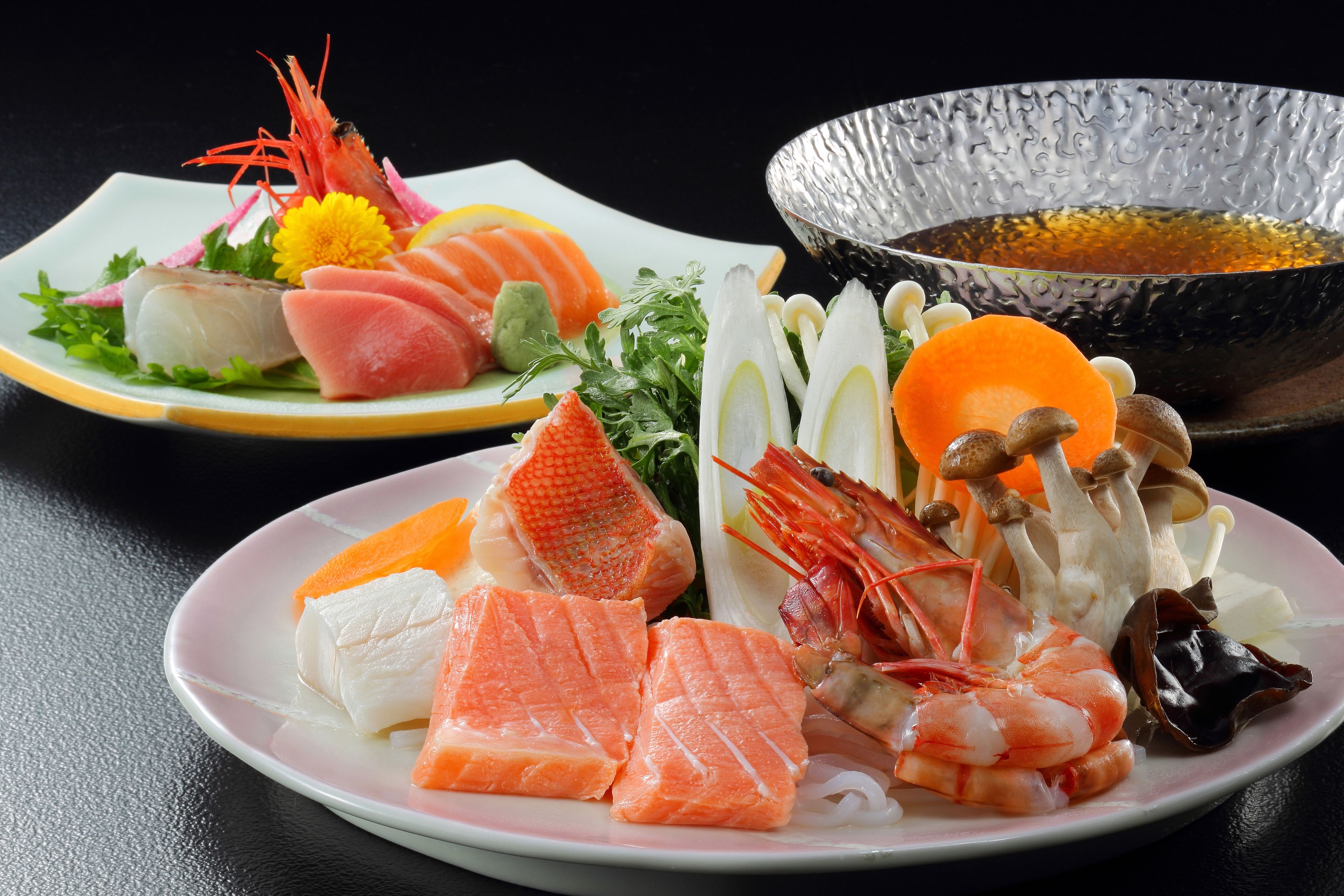 Un plato de sushi con varios ingredientes, como salmón, camarones y verduras.