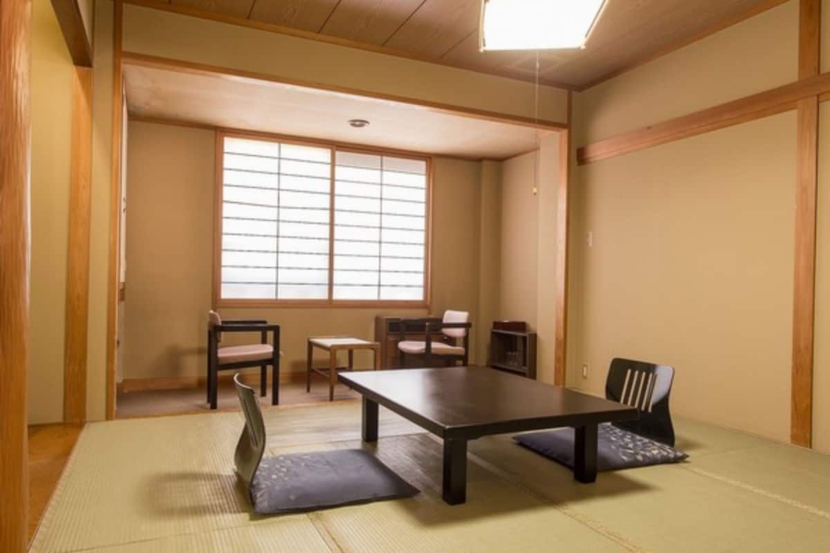 Ein traditioneller japanischer Raum mit Tatami-Böden, einem niedrigen Tisch und Schiebetüren.