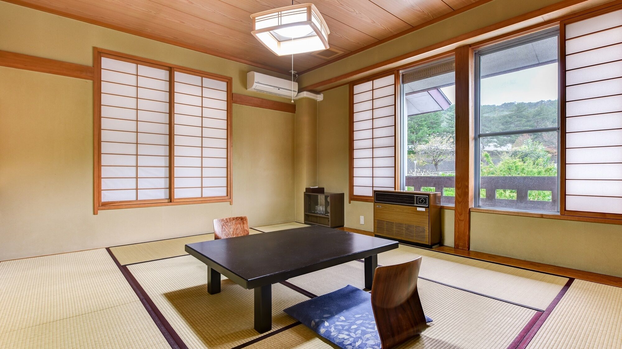 Um quarto japonês tradicional com piso de tatame, uma mesa baixa e portas deslizantes.