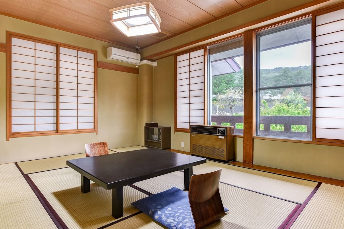 Ein traditioneller japanischer Raum mit Tatami-Böden, einem niedrigen Tisch und Schiebetüren.