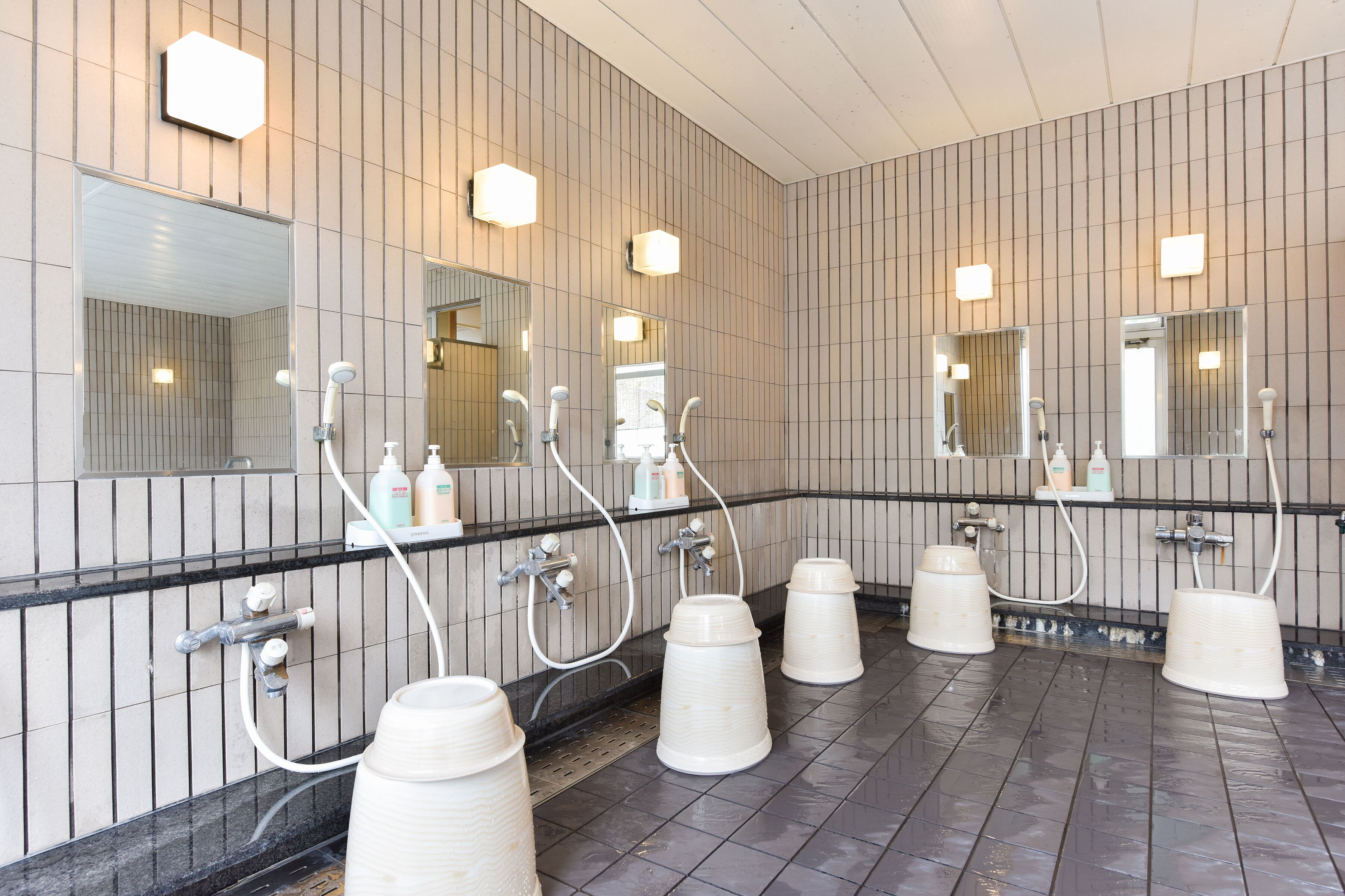 A public restroom with multiple sinks, mirrors, and hand dryers.
