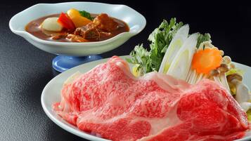 A plate of raw meat and a bowl of stew with vegetables.