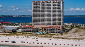 Un hotel grande con múltiples balcones que dan a una playa y al océano.
