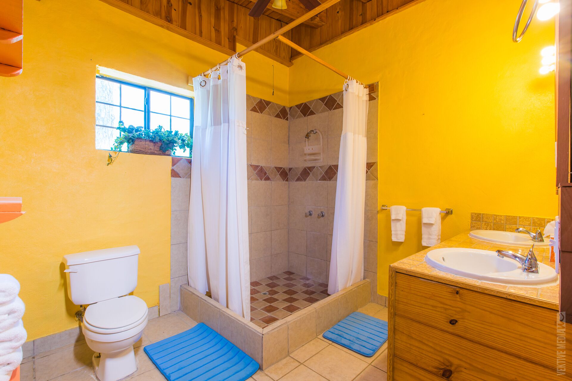 A bathroom with a shower, toilet, and sink.