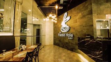 A restaurant interior with a marble countertop, a logo on the wall, and a seating area.