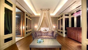 Una habitación con un sofá estampado, una mesa de centro de madera y un dosel decorativo.