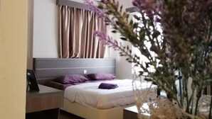 A modern bedroom with a bed, bedside table, and a potted plant. - Junikastay Blagoon Melaka (Malacca City)