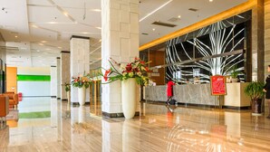 A spacious lobby with a marble floor, large potted plants, and a reception desk with a modern design. - Vilu Reef International Hotel (Zigong)