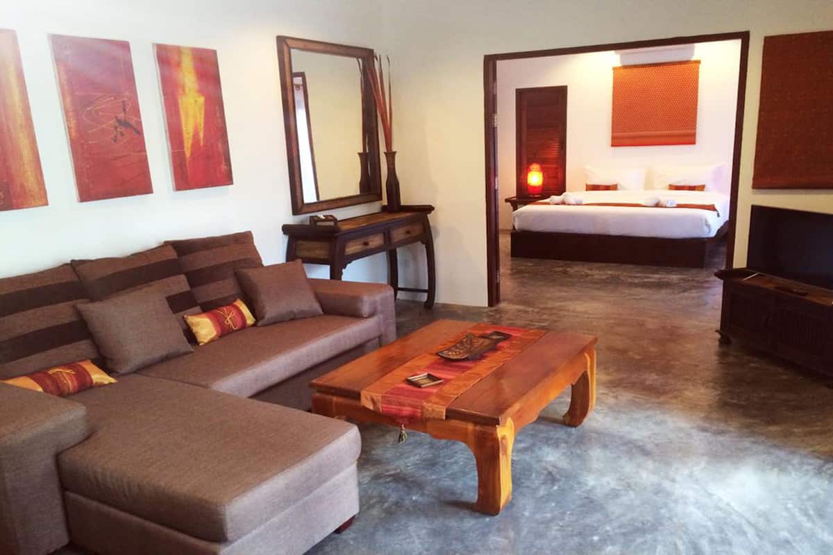 A modern living room with a brown sofa, a wooden coffee table, and a large mirror.