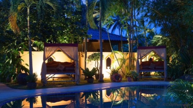 A resort with two overwater bungalows, each with a canopy bed and surrounded by lush tropical vegetation. - Sazana Villa Resort (Koh Samui)
