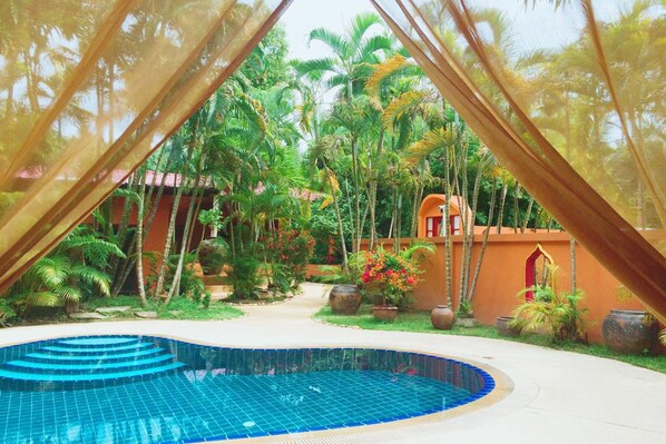 A pool area with a curved edge, surrounded by palm trees and potted plants. - Sazana Villa Resort (Koh Samui)