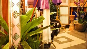 A hotel lobby with a checkered floor, potted plants, and hanging umbrellas. - The North Hotel (Chiang Rai)