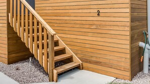 Un bâtiment moderne doté d’un escalier en bois menant à une zone couverte, marquée du numéro 2.