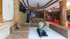A spacious lobby with a high ceiling, a staircase, and a reception area. - P R Patong Hotel (Patong)