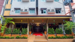 A hotel entrance with a red carpet, potted plants, and a central chandelier. - P R Patong Hotel (Patong)